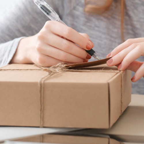 荷物の宛名を書く女性